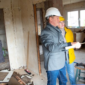 Bauherrenberater mit Bauherrin im zu sanierenden Altbau