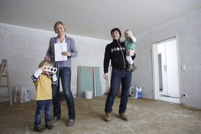 Bauherrenfamilie im halbfertigen Wohnzimmer